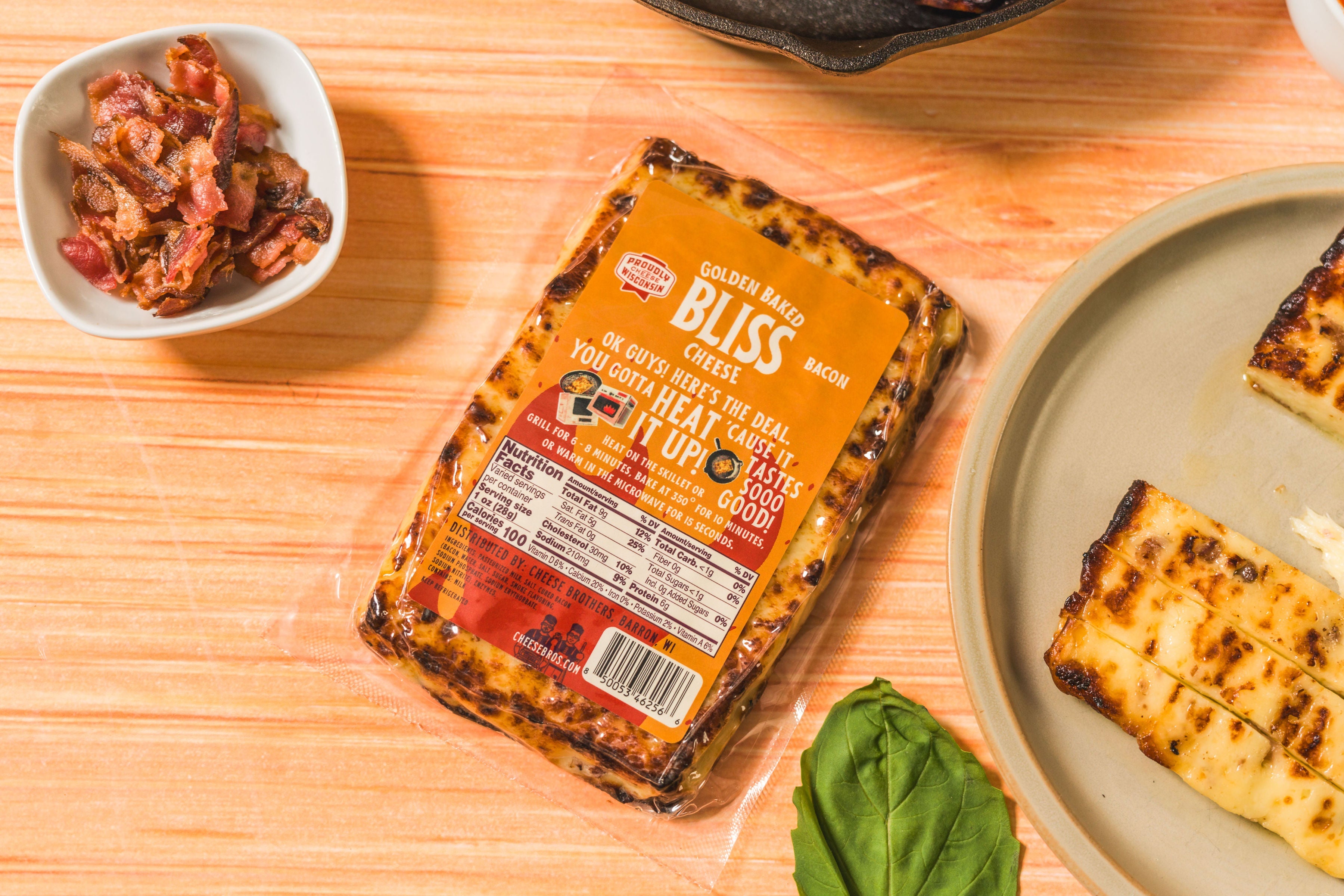 Golden baked Bliss cheese with crispy bacon pieces from Cheese Brothers, Inc., showcasing a cheesy baked snack with bacon bits.