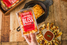 Golden Baked Bliss Cheese from Cheese Brothers, Inc. melted and baked with a crispy golden crust, showcasing its creamy cheese interior.
