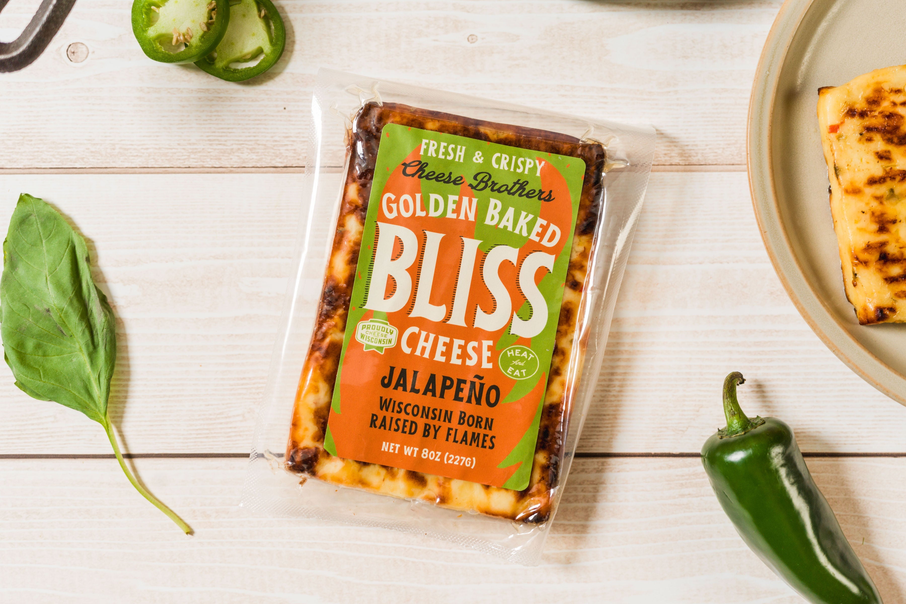 Golden baked Jalapeño cheese snack by Cheese Brothers, Inc., showing crispy cheese with jalapeño slices and melted cheese texture.