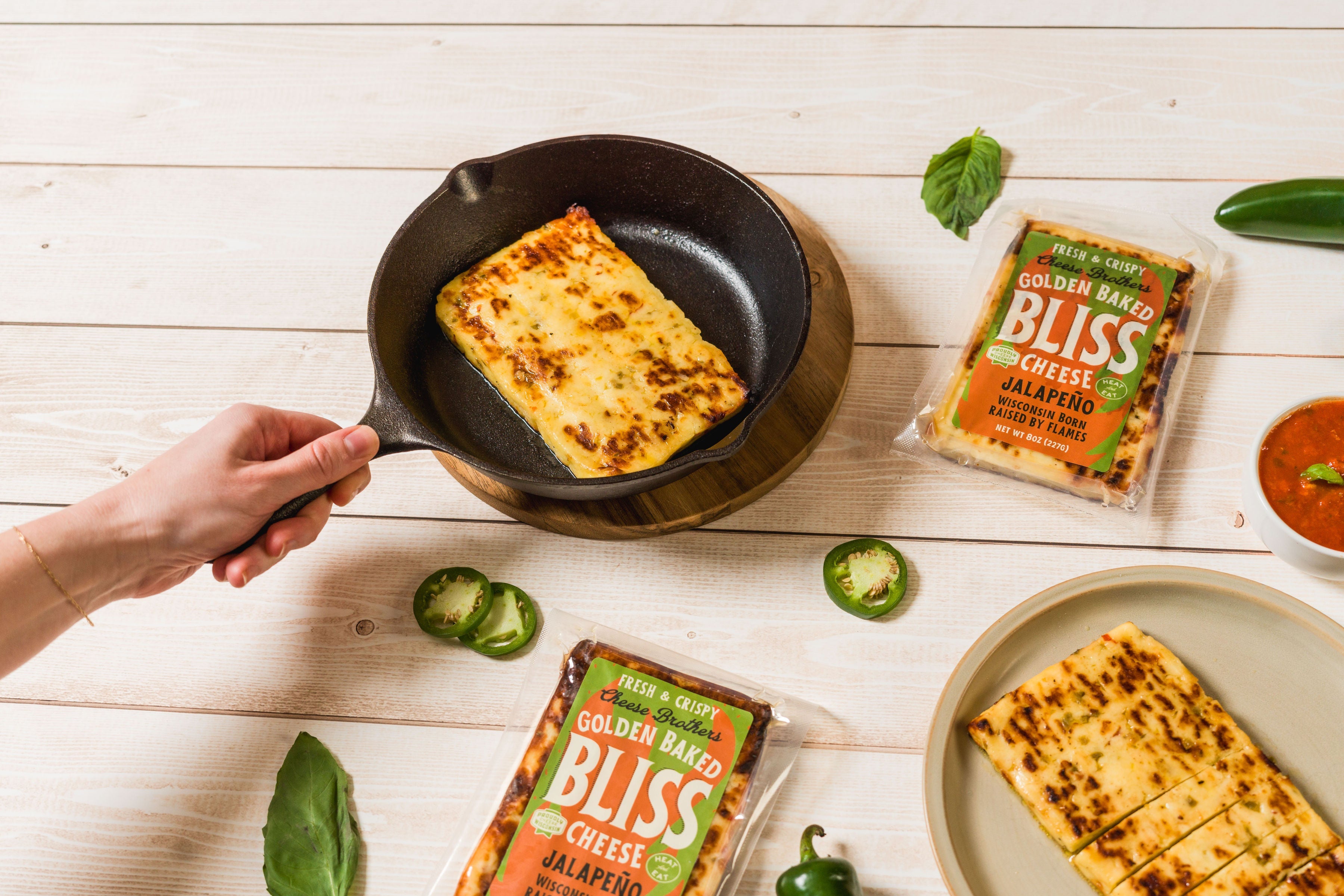 Golden baked jalapeño cheese snack from Cheese Brothers, Inc., showing crispy cheese with jalapeño slices on top.