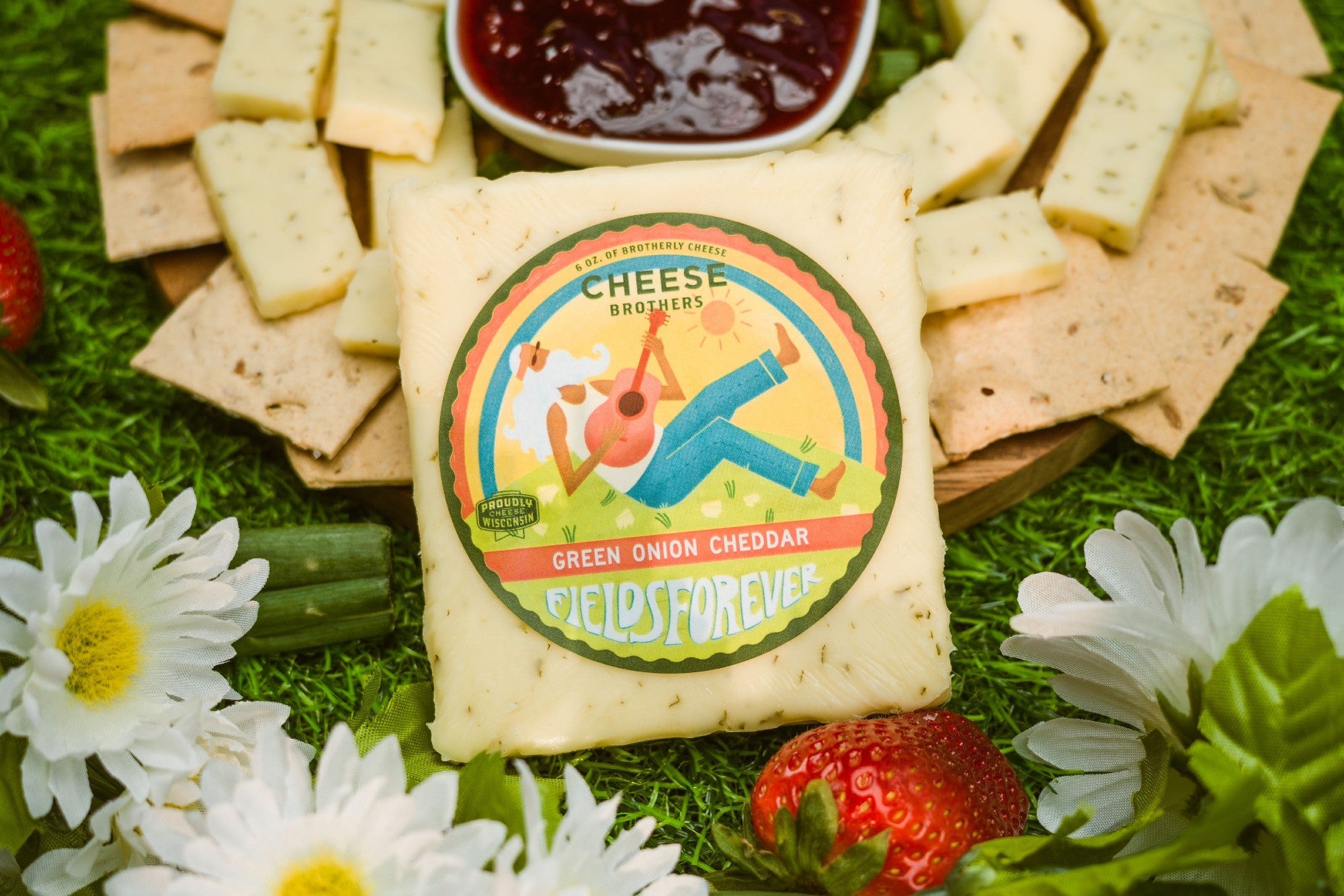 Creamy green onion cheddar cheese from Cheese Brothers, Inc., featuring vibrant green onions mixed into a rich cheddar block.