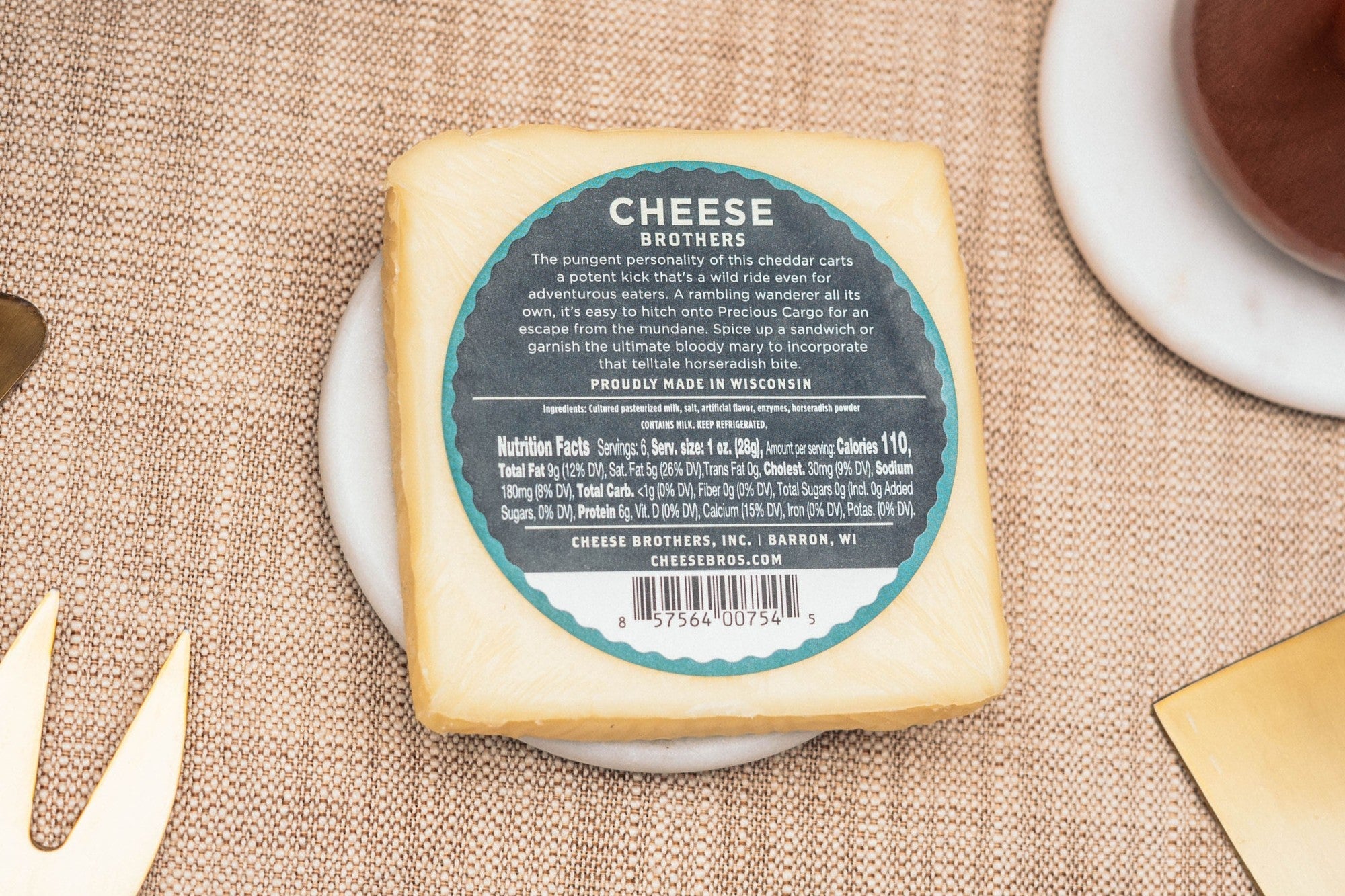 Slice of Precious Cargo horseradish cheddar cheese from Cheese Brothers, Inc., showing its marbled texture and spicy horseradish flavor.