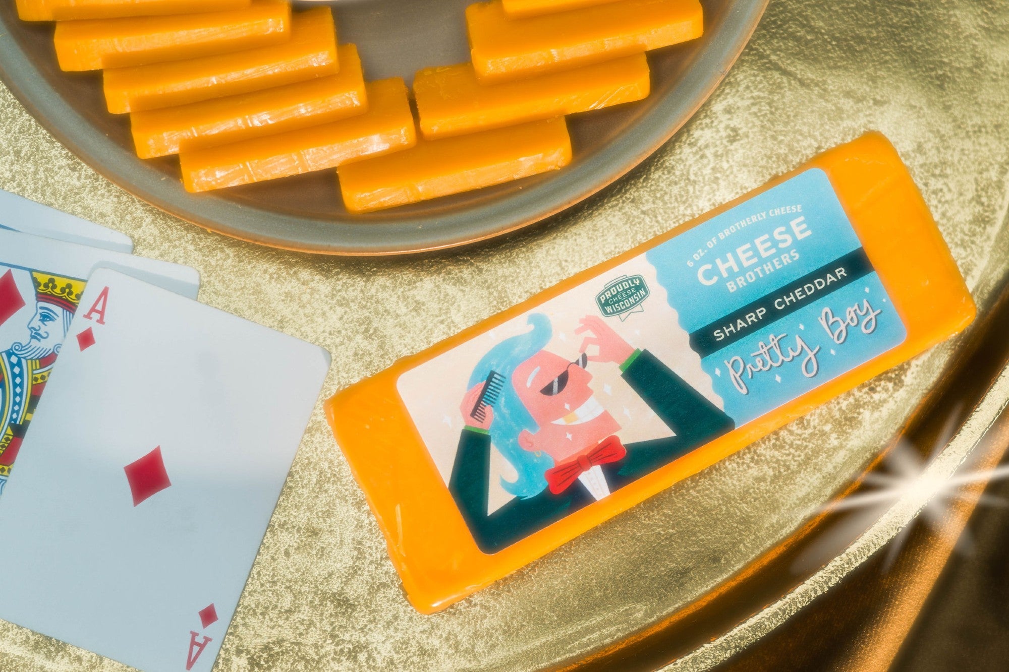 Slice of "Pretty Boy" Sharp Cheddar cheese from Cheese Brothers, Inc., showcasing its rich orange color and smooth texture.