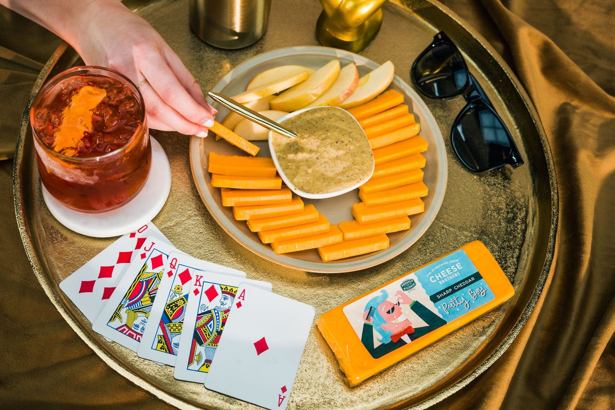 Slices of "Pretty Boy" Sharp Cheddar cheese from Cheese Brothers, Inc., showcasing its rich, vibrant orange color and smooth texture.