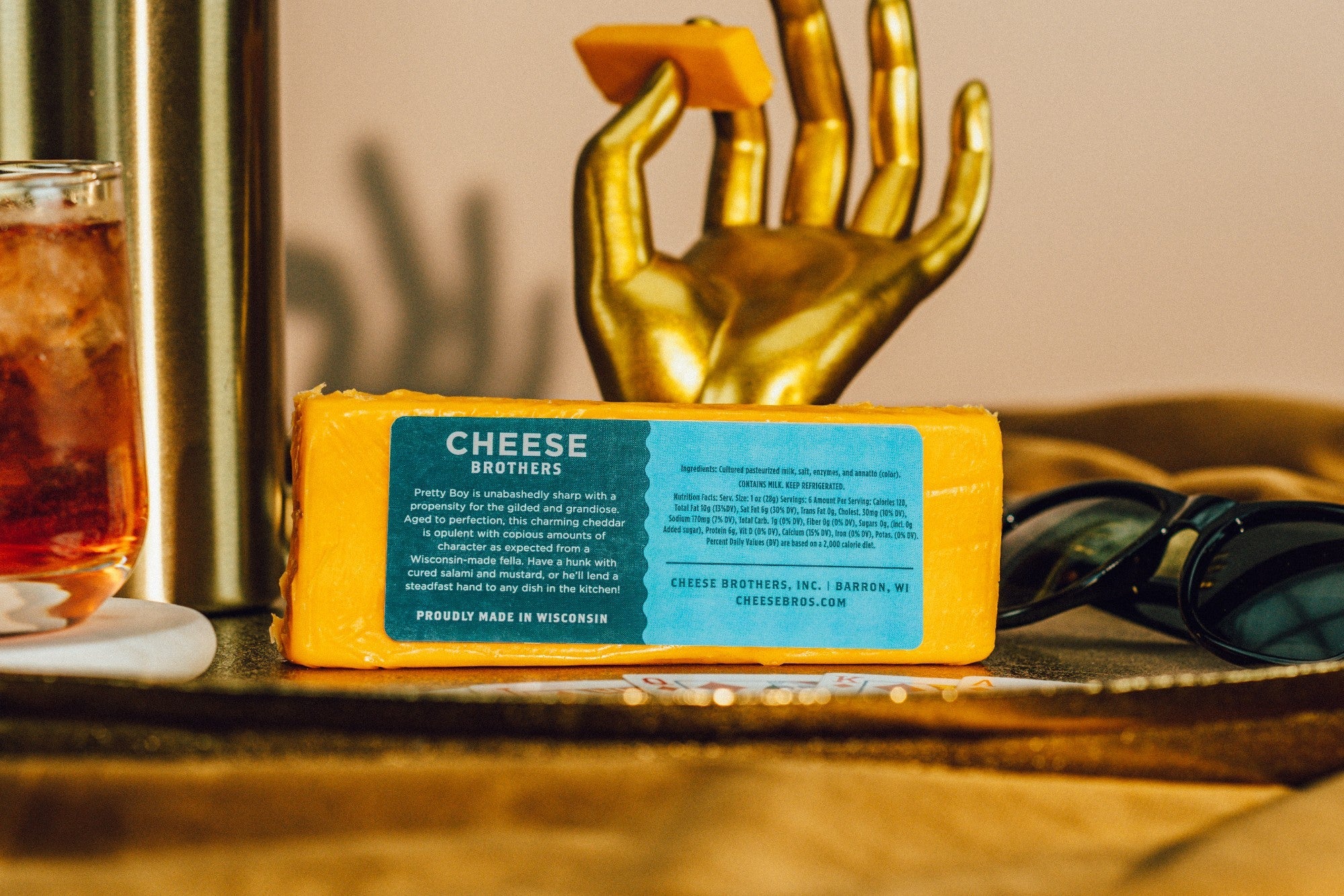 Slice of "Pretty Boy" Sharp Cheddar cheese from Cheese Brothers, Inc., showing bright orange color and firm texture.