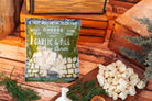 Creamy Garlic and Dill Cheese Curds by Cheese Brothers, Inc. with fresh garlic and dill herbs, shown in a close-up image.