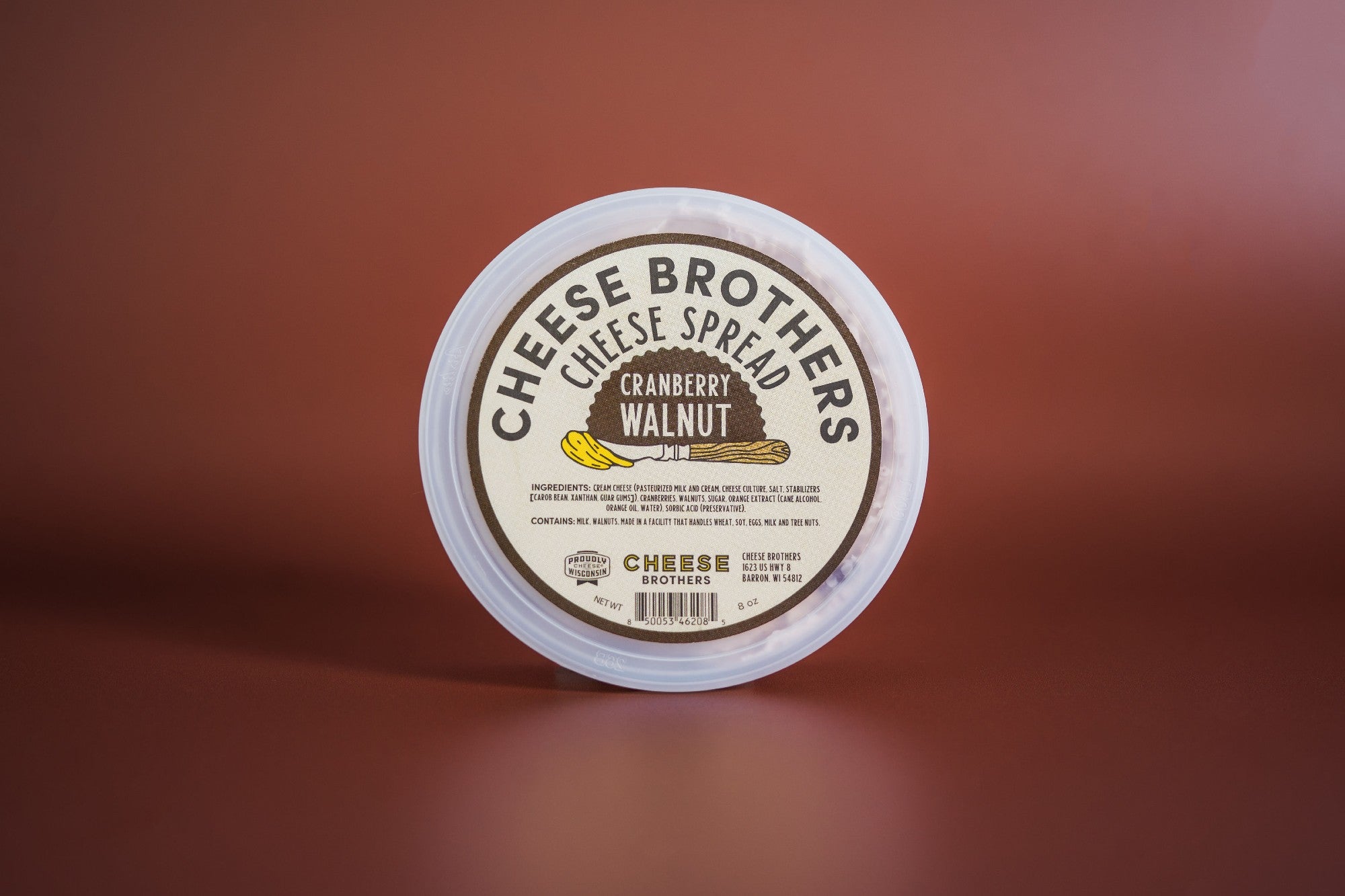 Creamy cranberry walnut cheese spread by Cheese Brothers, Inc. in a jar with visible cranberries and walnuts.