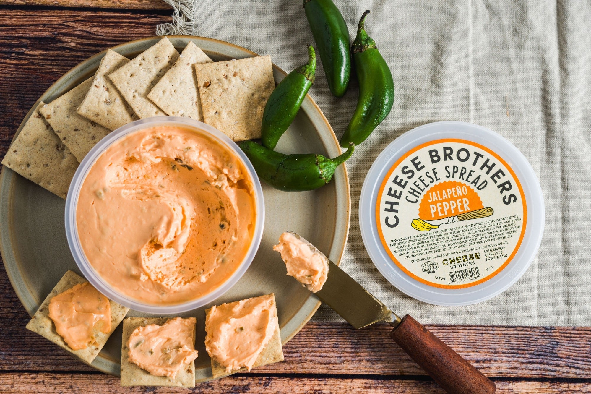 Creamy jalapeño pepper cheese spread from Cheese Brothers, Inc., showing a vibrant green jalapeño pepper on a smooth cheese spread.