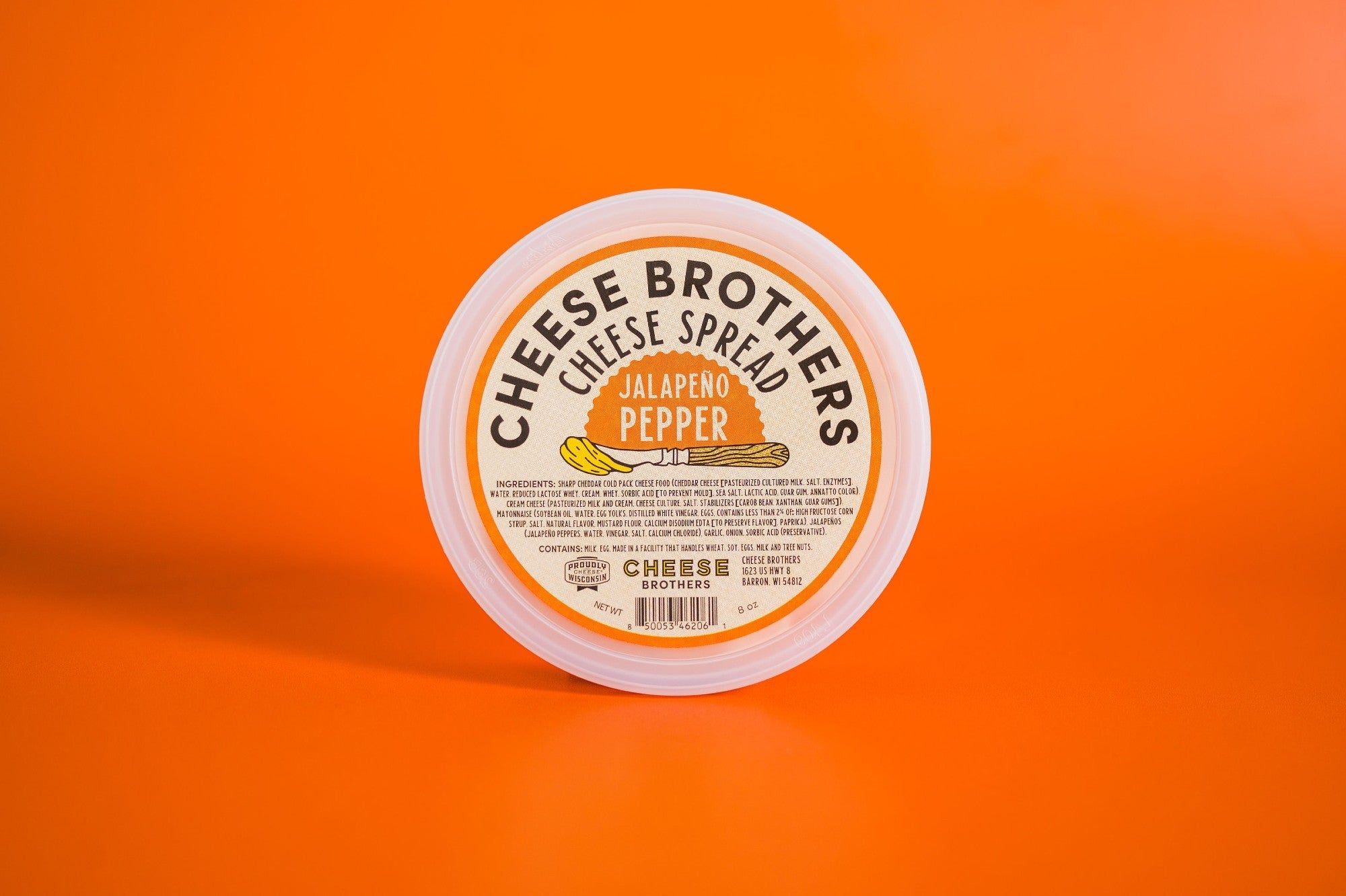 Creamy jalapeño pepper cheese spread by Cheese Brothers, Inc., featuring vibrant green jalapeño peppers and smooth cheese texture.