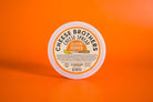 Creamy jalapeño pepper cheese spread by Cheese Brothers, Inc., featuring vibrant green jalapeño peppers and smooth cheese texture.