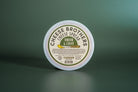 Creamy onion and chive cheese spread by Cheese Brothers, Inc. in a jar with fresh herbs visible, perfect for spreading or dipping.