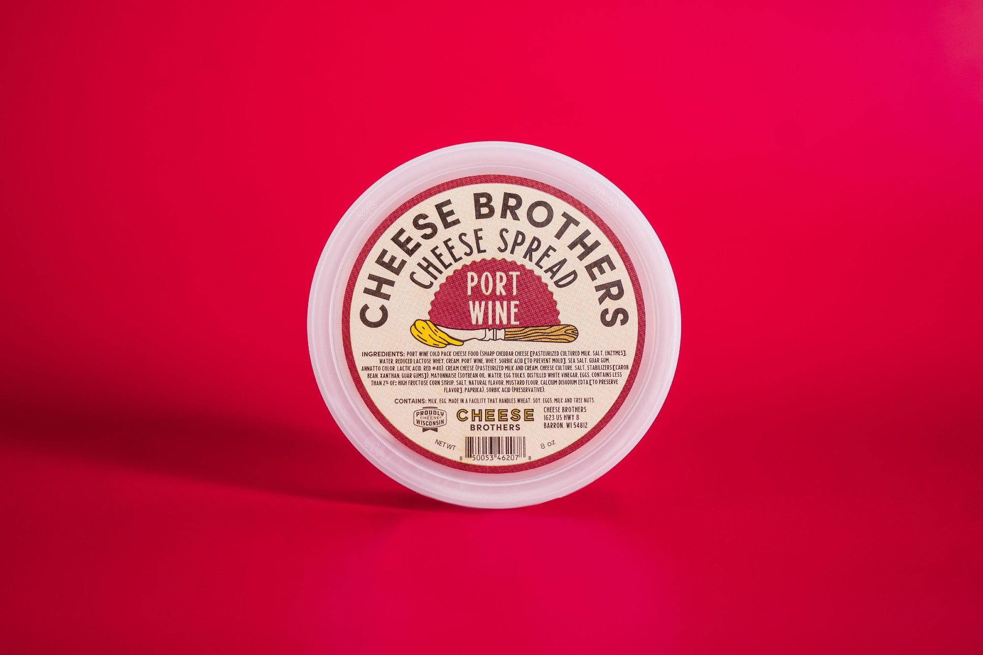 Creamy Port Wine Cheese Spread by Cheese Brothers, Inc. in a jar, showcasing its smooth texture and rich port wine flavor.