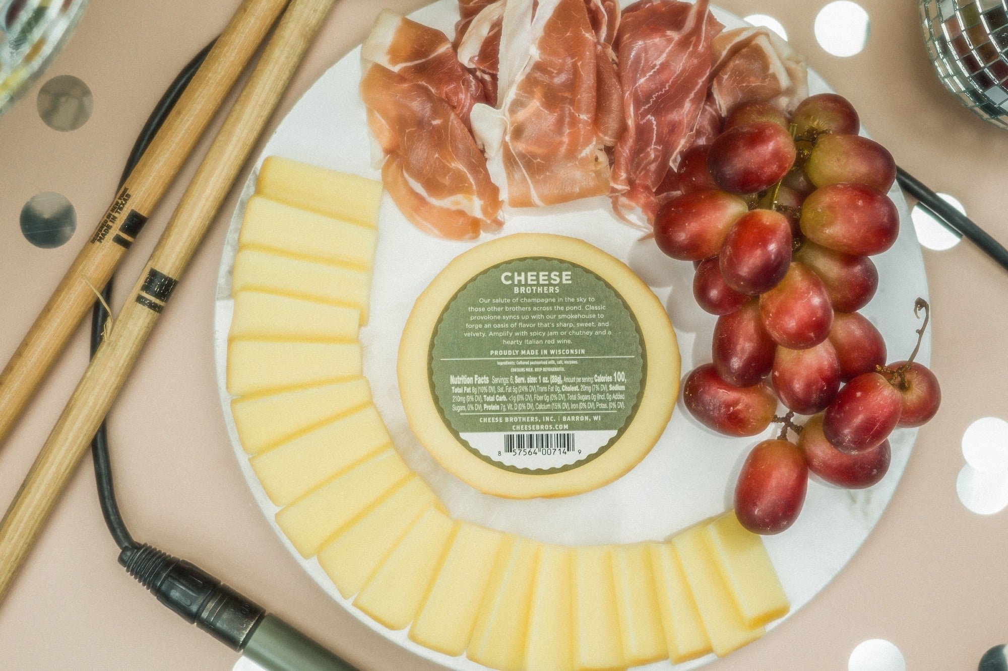 Sliced smoked provolone cheese from Cheese Brothers, Inc., showing its smooth, pale yellow interior and smoked flavor.