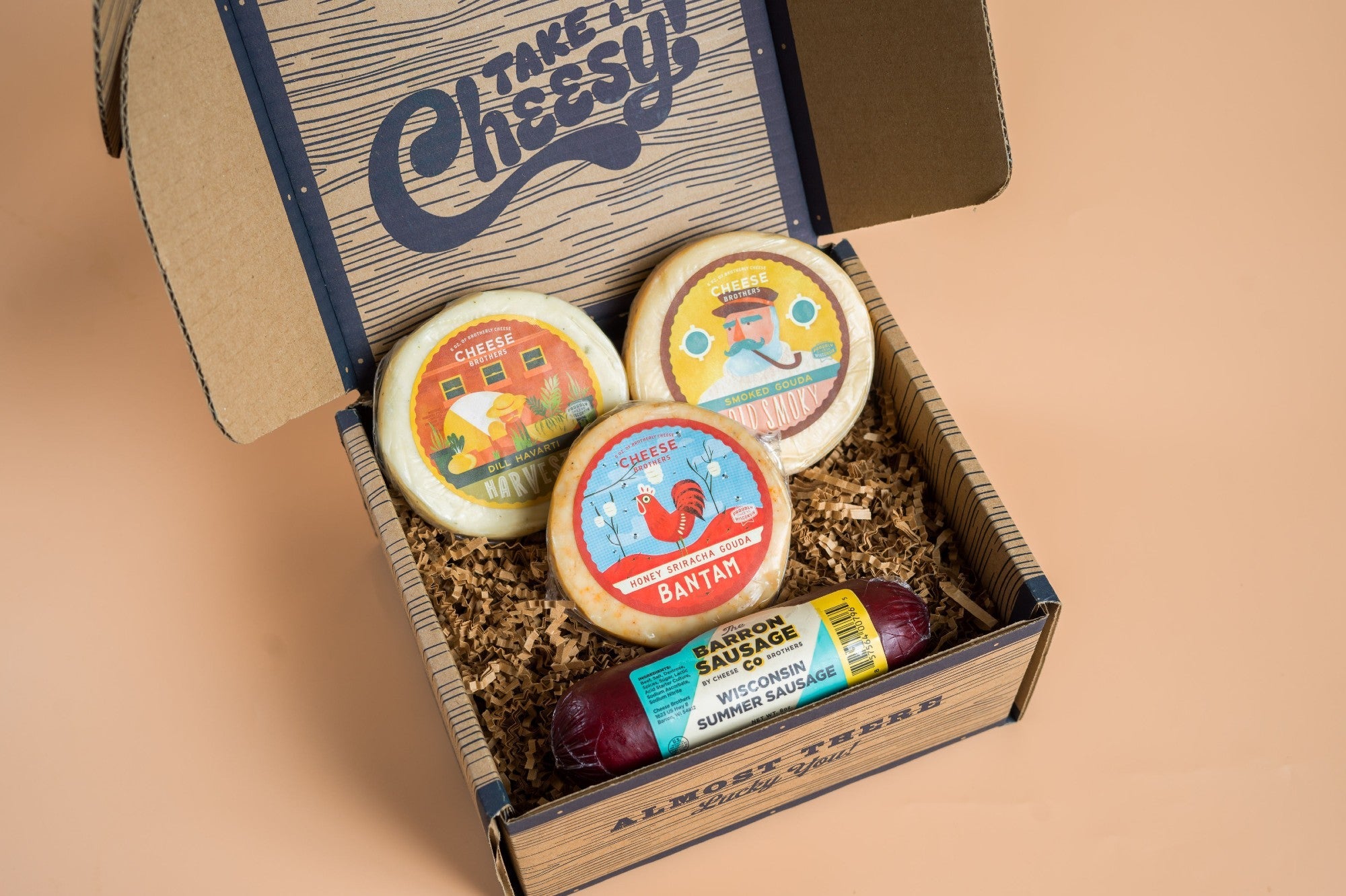 Assorted cheese and sausage sampler pack featuring slices of cheese and cured sausages from Cheese Brothers, Inc.