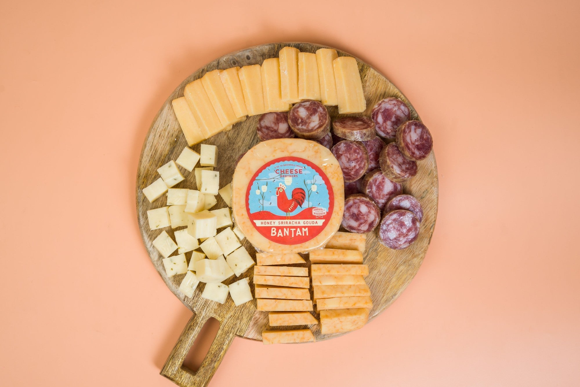 Assorted cheese and sausage sampler pack from Cheese Brothers, Inc., featuring slices of gourmet cheeses and cured sausages.