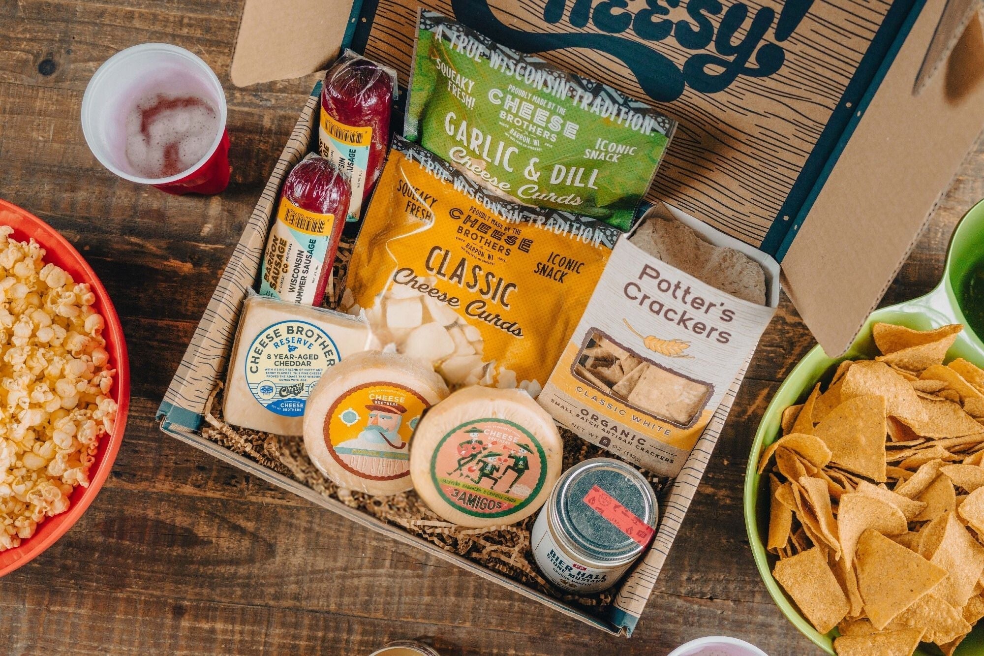 Cheese Brothers Deluxe Game Day Essentials Gift Pack including snacks and drinks in a branded gift box for sports fans.