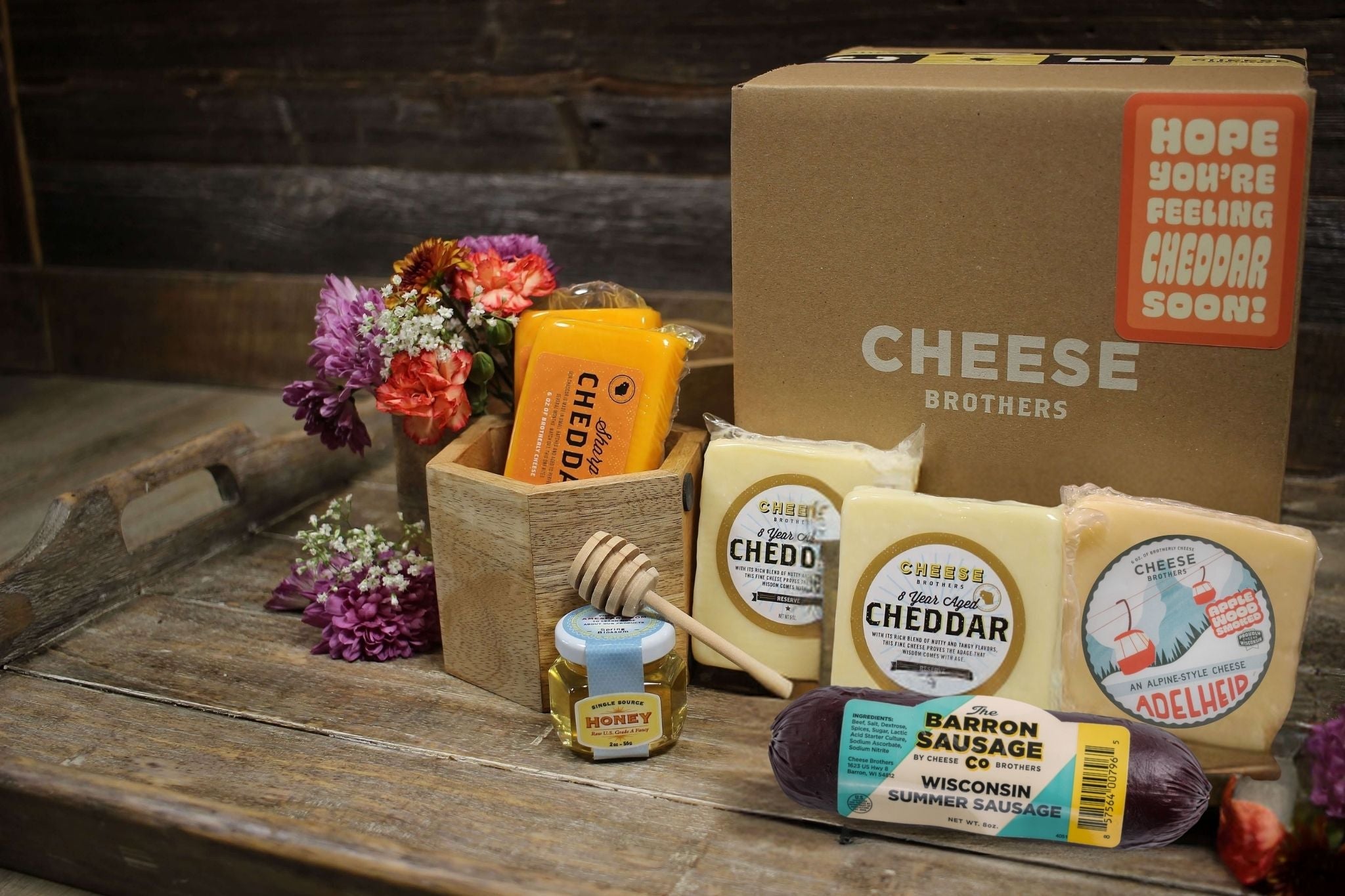 Cheddar cheese gift basket from Cheese Brothers, Inc. featuring assorted cheeses and snacks in a decorative gift bundle.