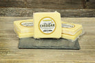 Cheese Brothers Inc. gift basket featuring aged 8-year cheddar cheese, crackers, and gourmet snack items in a decorative bundle.