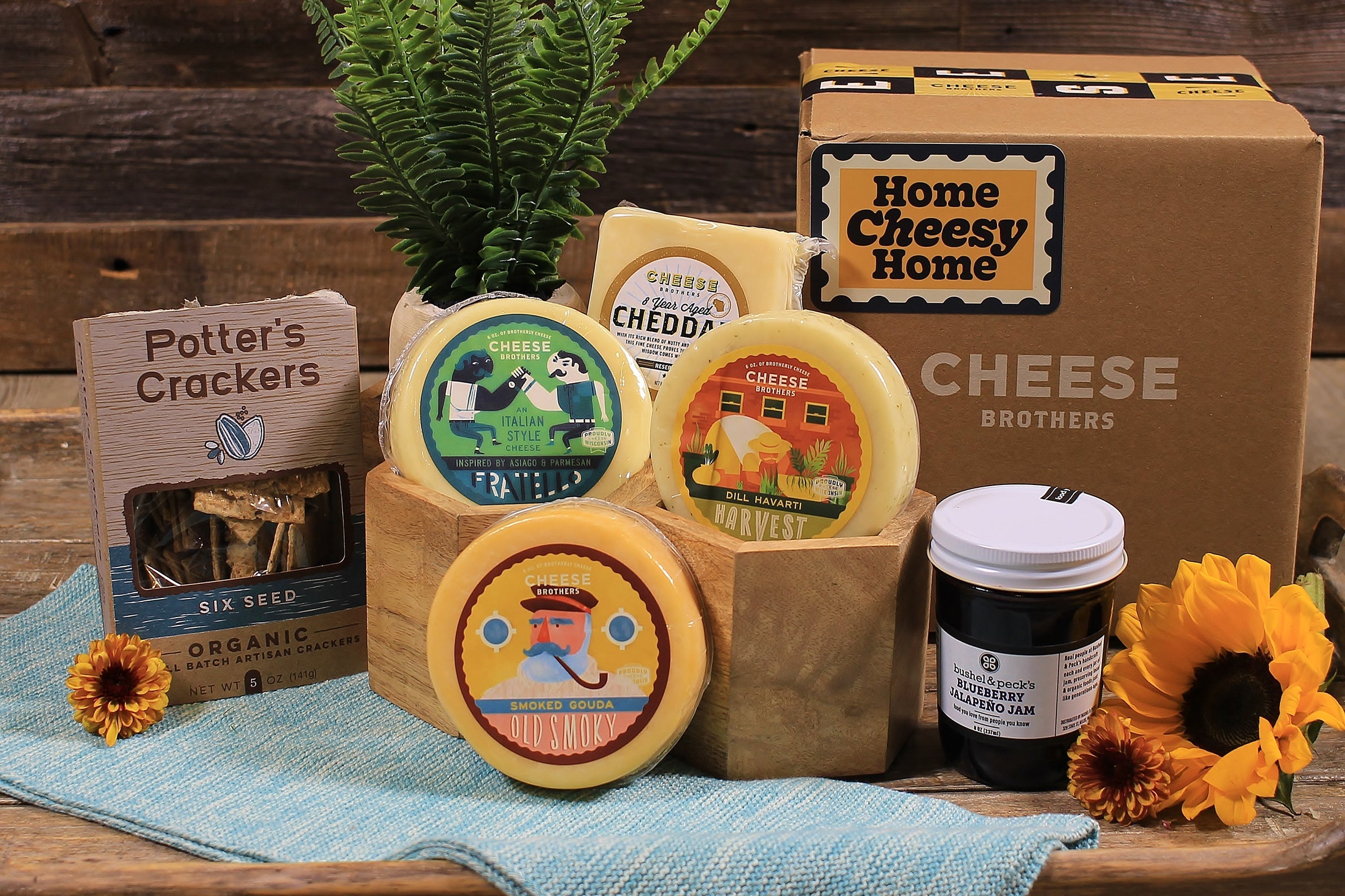 Cheese Brothers Inc. housewarming gift basket with assorted cheeses, crackers, and gourmet snacks for new homeowners