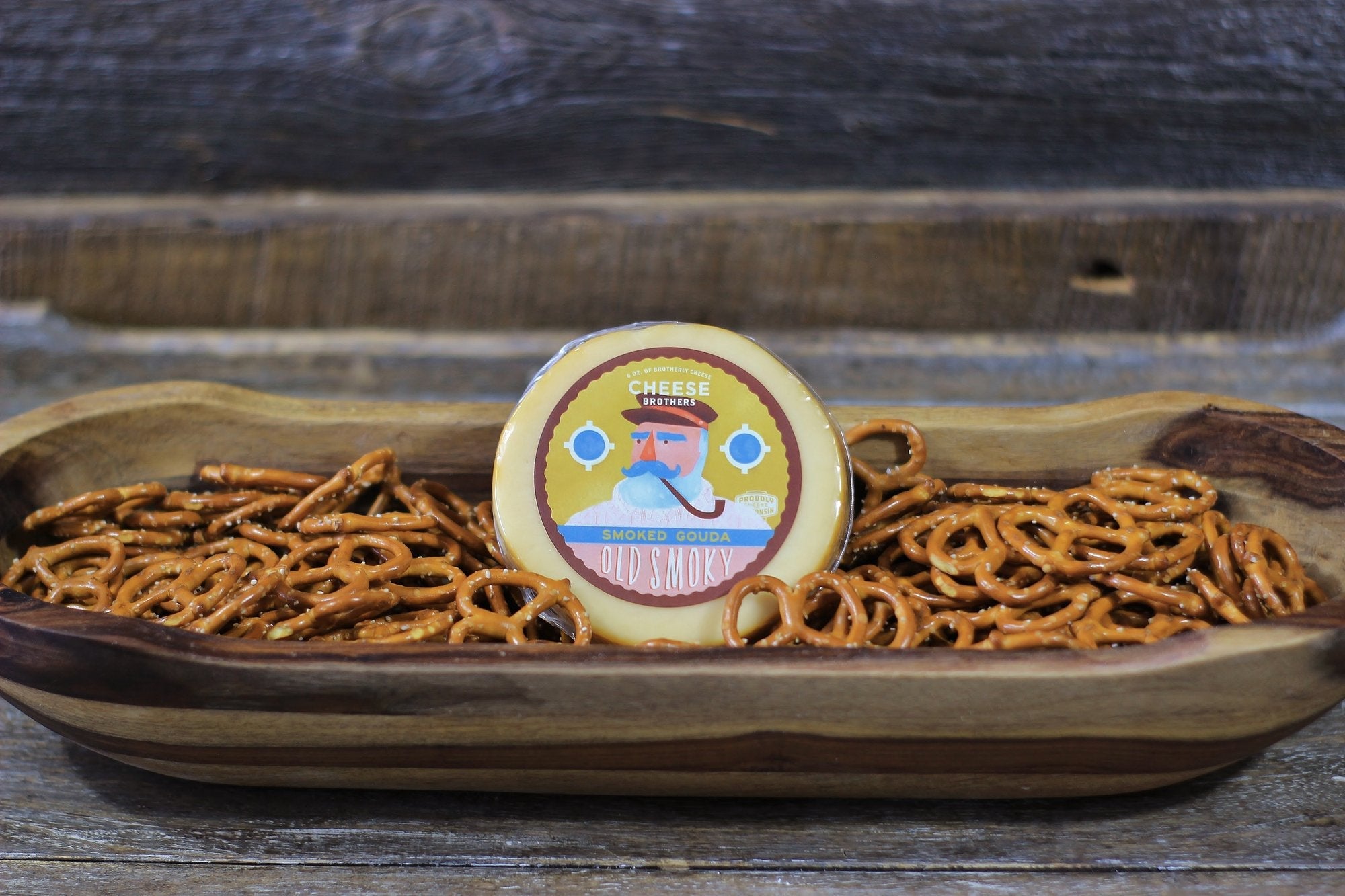 Smoked Gouda cheese from Cheese Brothers, Inc. in a housewarming gift basket with assorted gourmet snacks and treats.