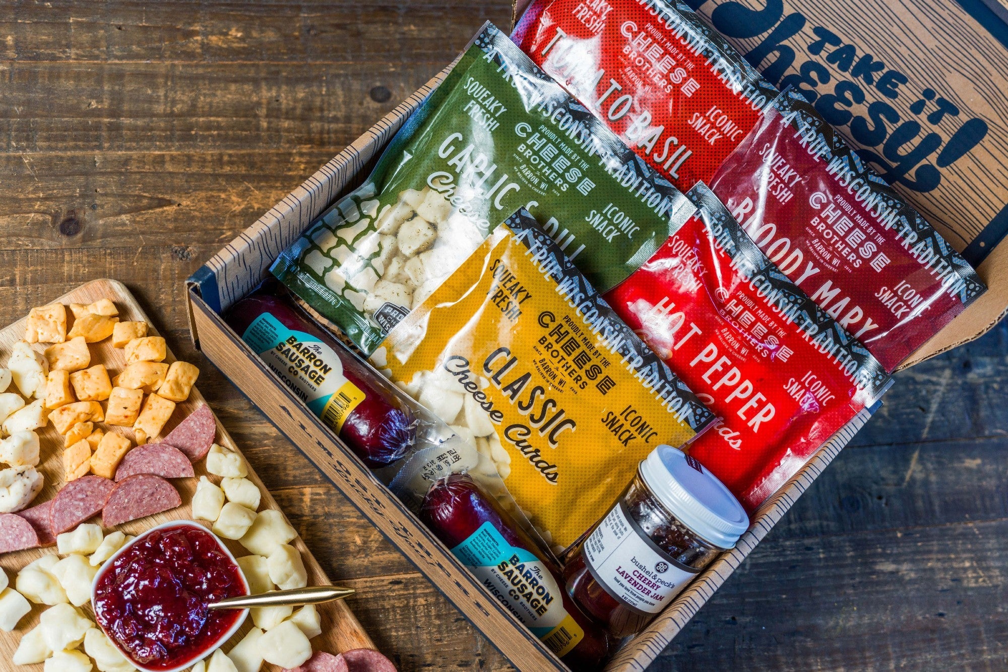 Char-CURD-erie cheese and charcuterie gift box from Cheese Brothers, Inc., featuring an assortment of cheeses and cured meats.