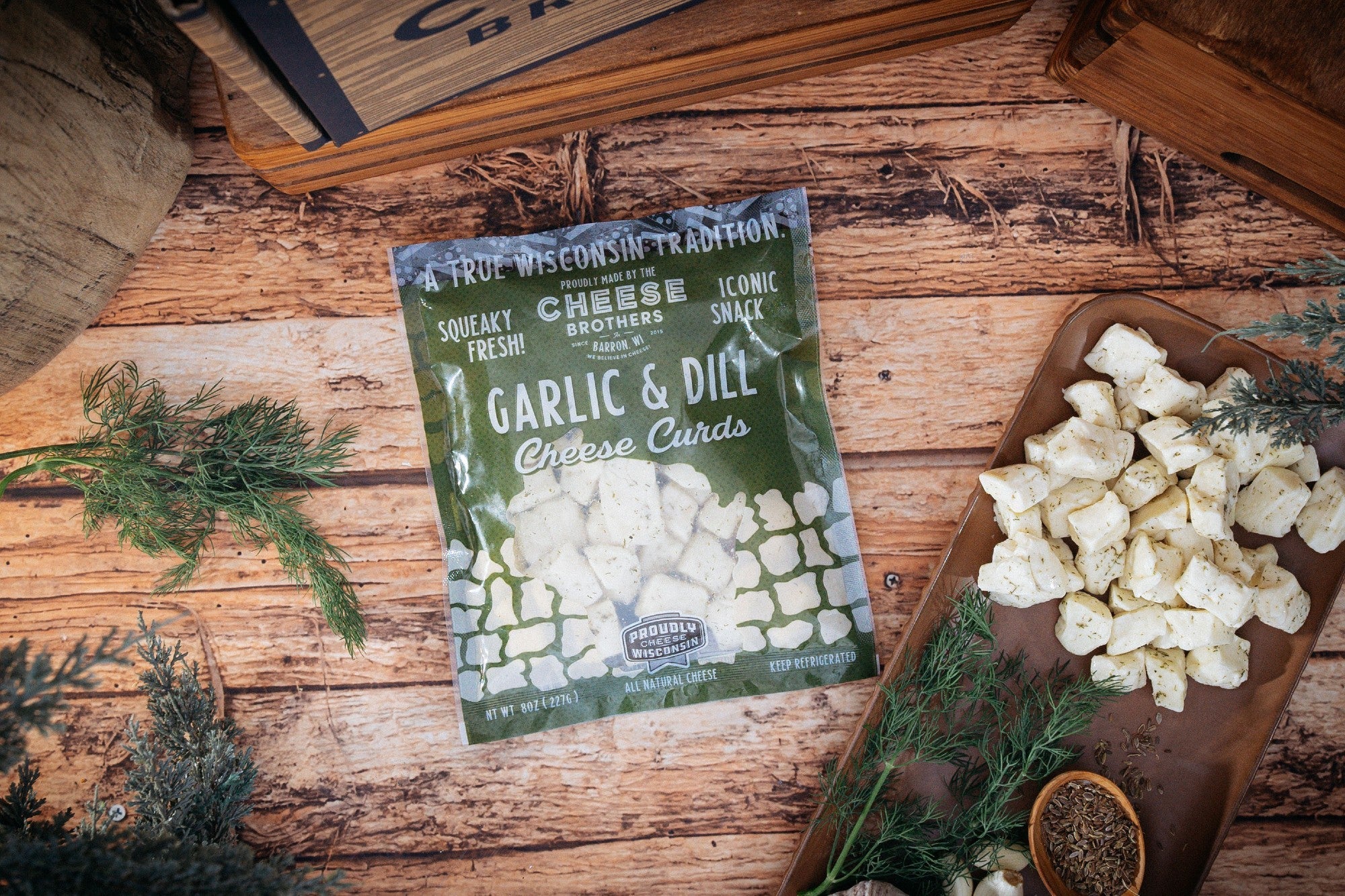 Garlic and dill cheese spread from Cheese Brothers Char-CURD-erie gift box, creamy and flavorful, in a glass jar with fresh herbs.