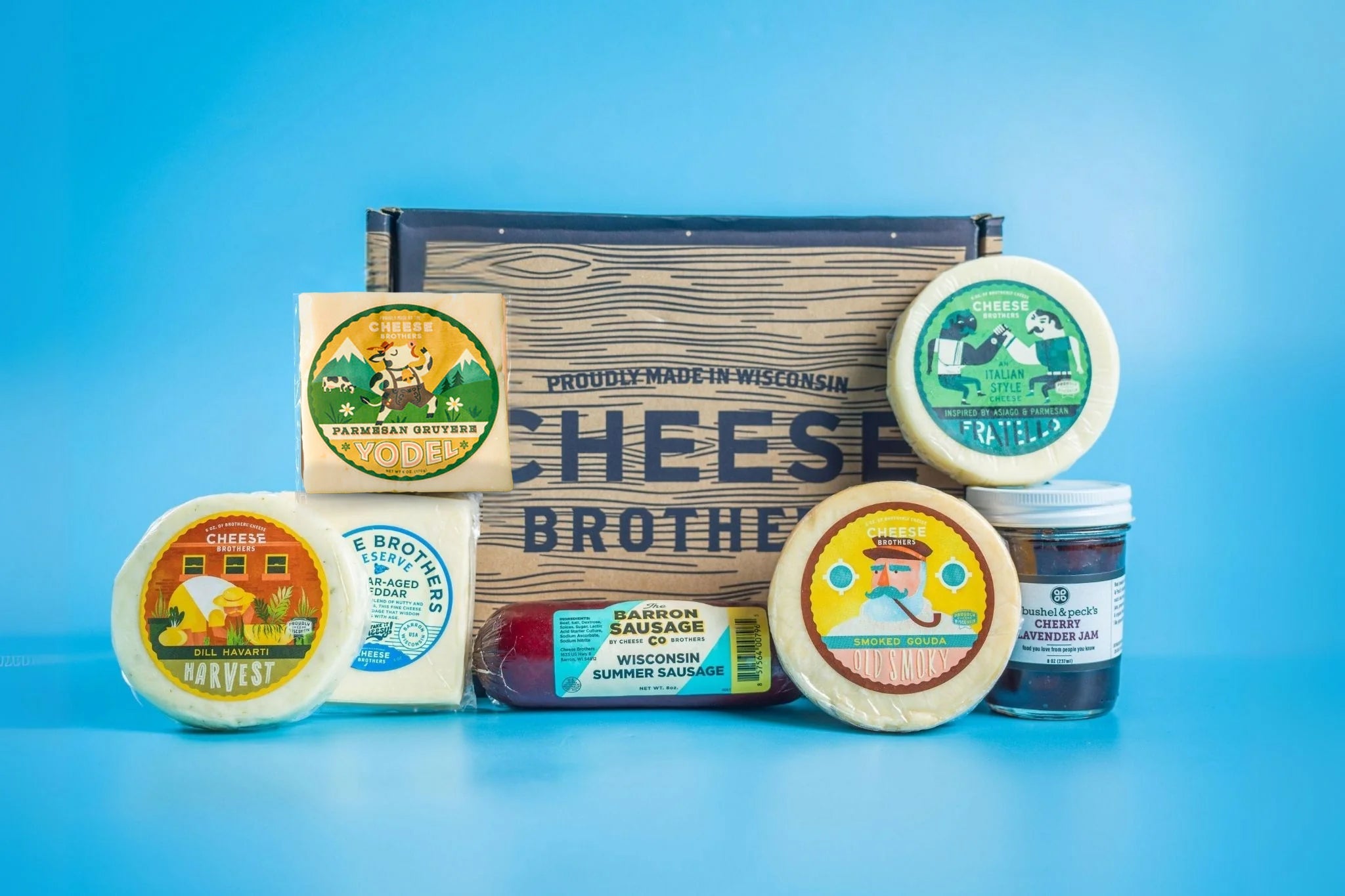 Assorted cheese and cured meats in a charcuterie box from Cheese Brothers, Inc., with crackers and garnishes for a gourmet gift.
