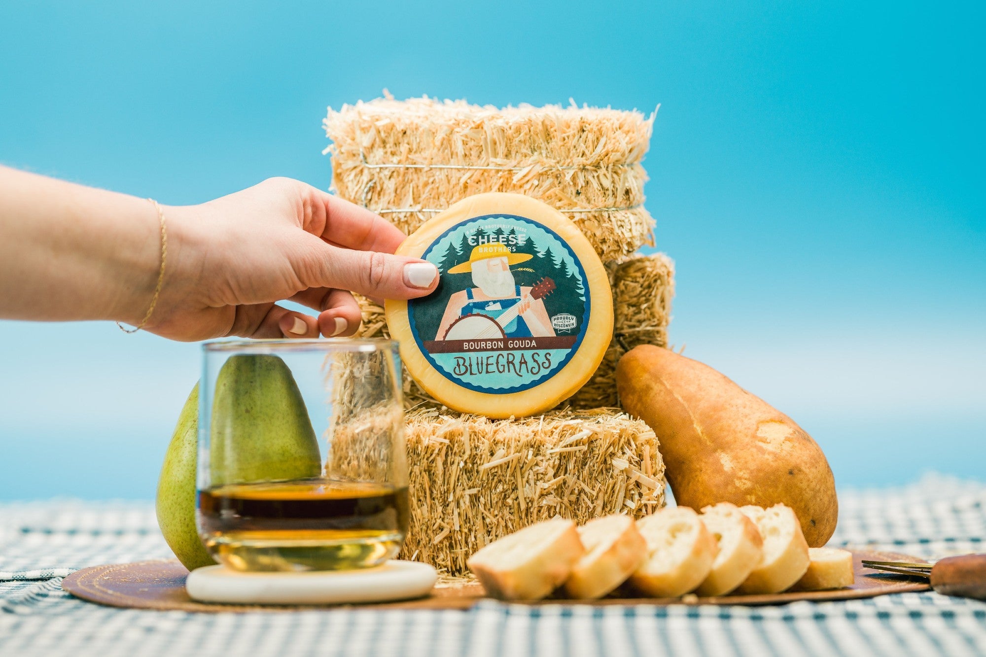 Creamy Bluegrass Bourbon Gouda cheese from Cheese Brothers Inc., showing a wedge of smooth, yellow Gouda with bourbon-infused flavor.