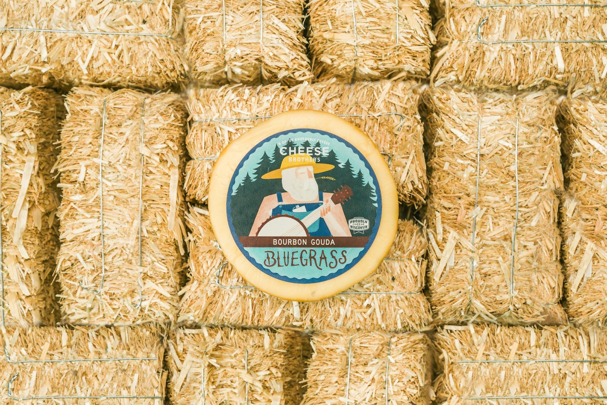 Creamy Bluegrass Bourbon Gouda cheese from Cheese Brothers, Inc., showing a wedge of rich, smooth Gouda with a blue hue and bourbon infusion.