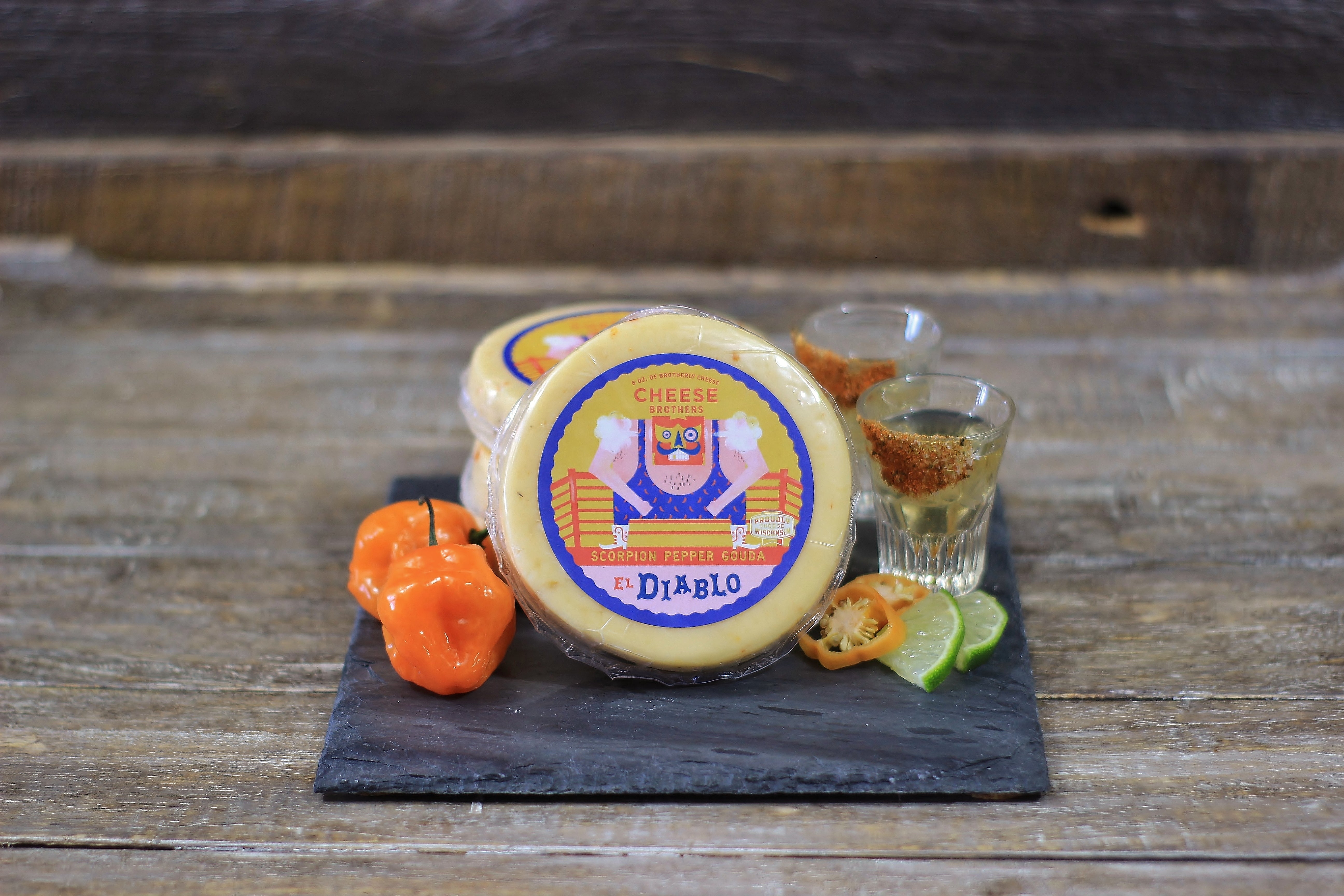 Spicy El Diablo Scorpion Pepper Gouda cheese by Cheese Brothers, Inc. showing a block of Gouda with visible chili pepper flakes