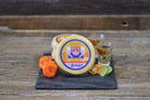 Spicy El Diablo Scorpion Pepper Gouda cheese by Cheese Brothers, Inc. showing a block of Gouda with visible chili pepper flakes