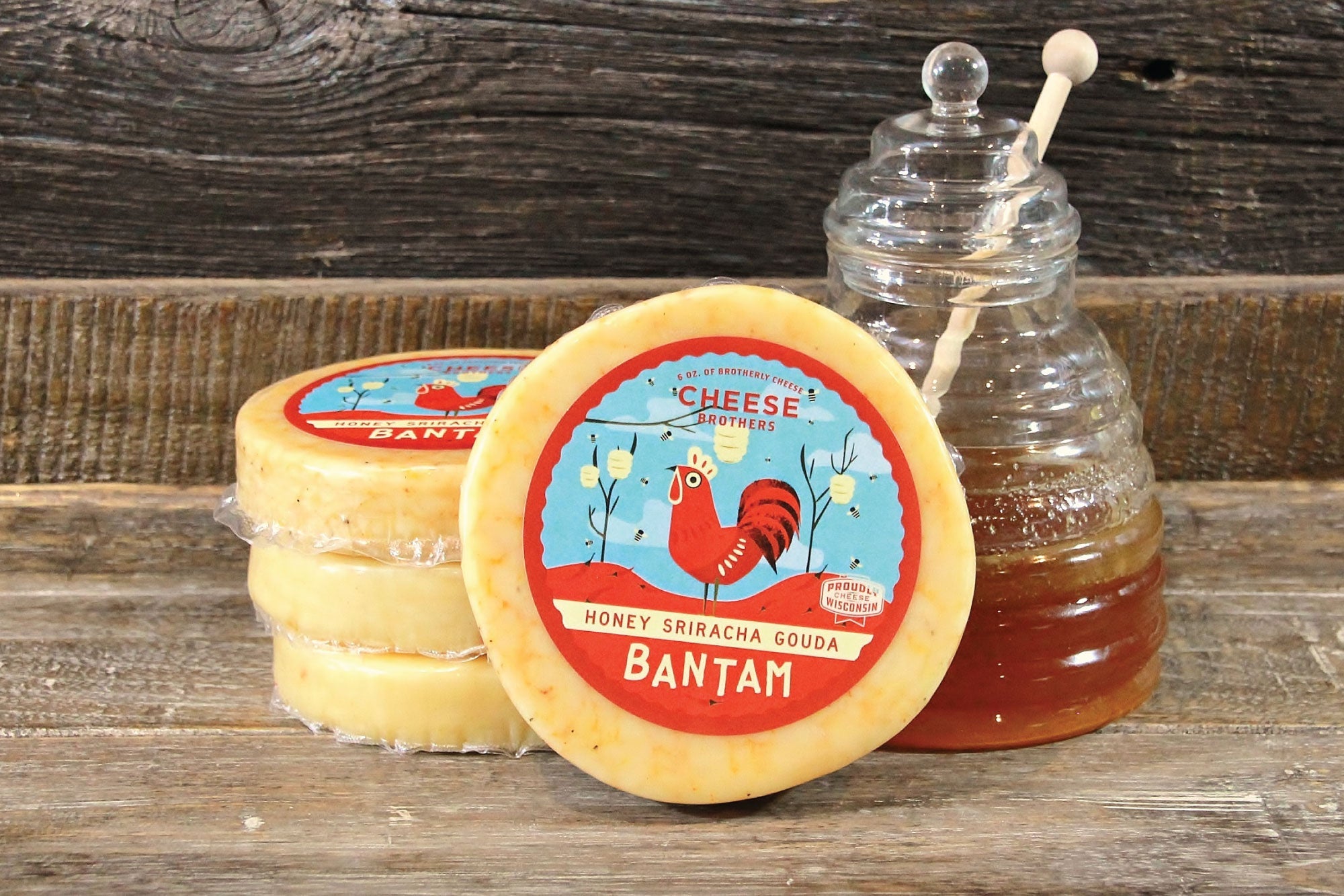 Slices of Honey Sriracha Gouda cheese from Cheese Brothers, Inc., showing creamy texture with swirls of honey and sriracha sauce.