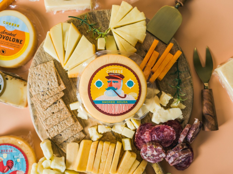 Smoked Gouda cheese by Cheese Brothers, Inc. showing a wheel of smoked Gouda cheese with a rich, smoky brown rind.