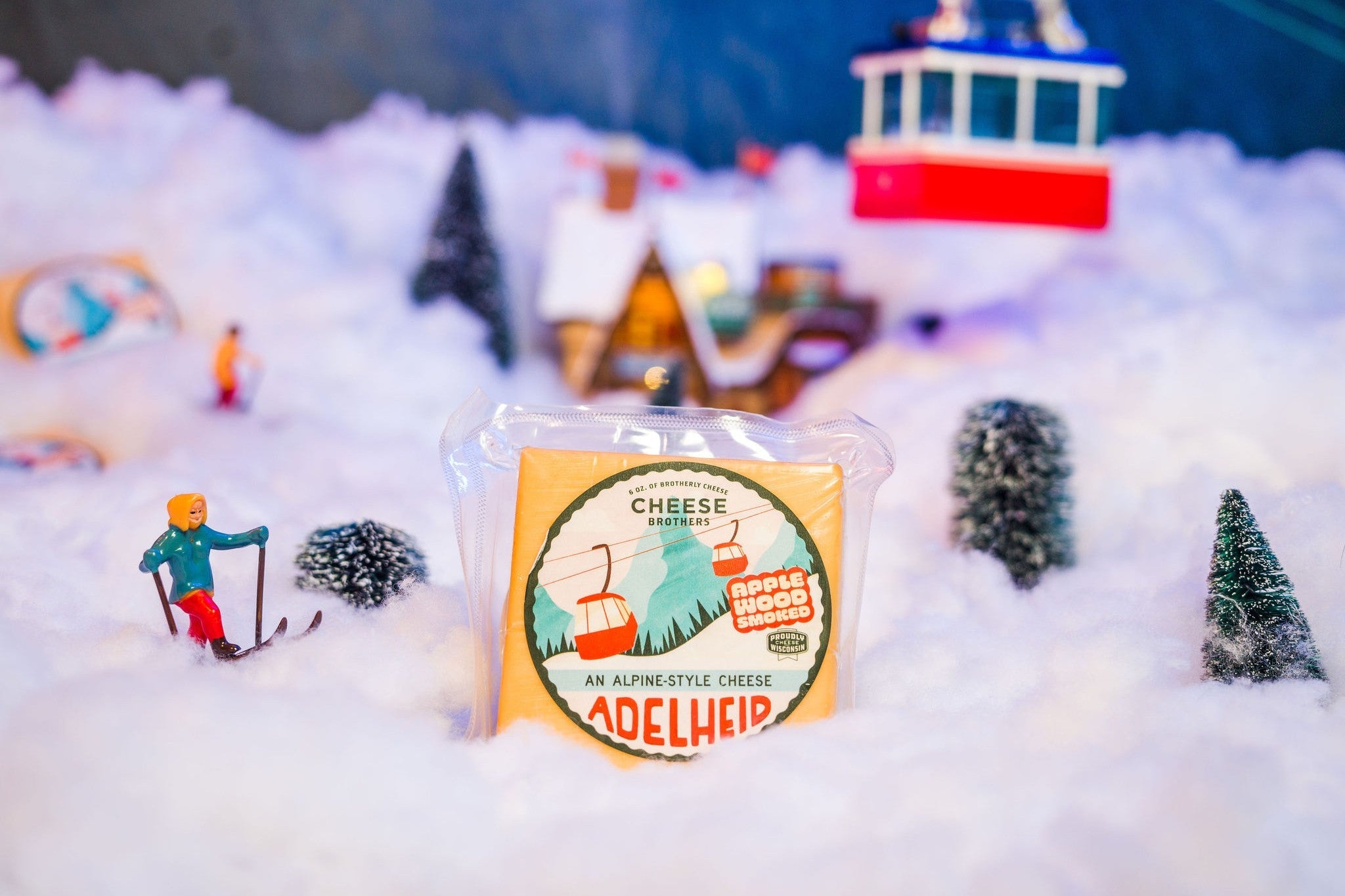 Creamy Adelheid Alpine-Style Cheese by Cheese Brothers, Inc., sliced and ready to serve on a wooden cheese board.