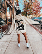 Back view of a black hoodie featuring the "Fueled by Cafecito Y Chisme" design, made by Shop Karma Tees.