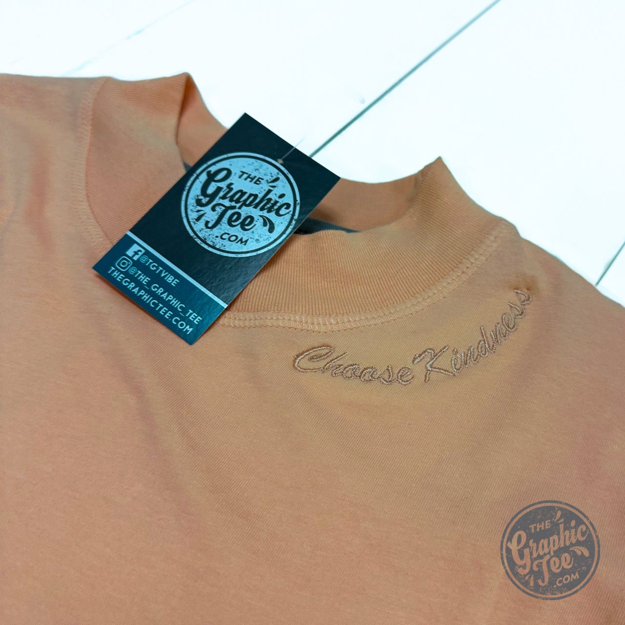 White Choose Kindness waist-length crop tee by The Graphic Tee, featuring a casual graphic design on the front.