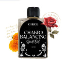 Small bottle of Circe Boutique Chakra Balancing Oil for energy alignment, with colorful crystals and spiritual herbs around it.