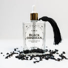 Black obsidian gemstone and ritual body oil from Circe Boutique, designed for protection and spiritual healing.