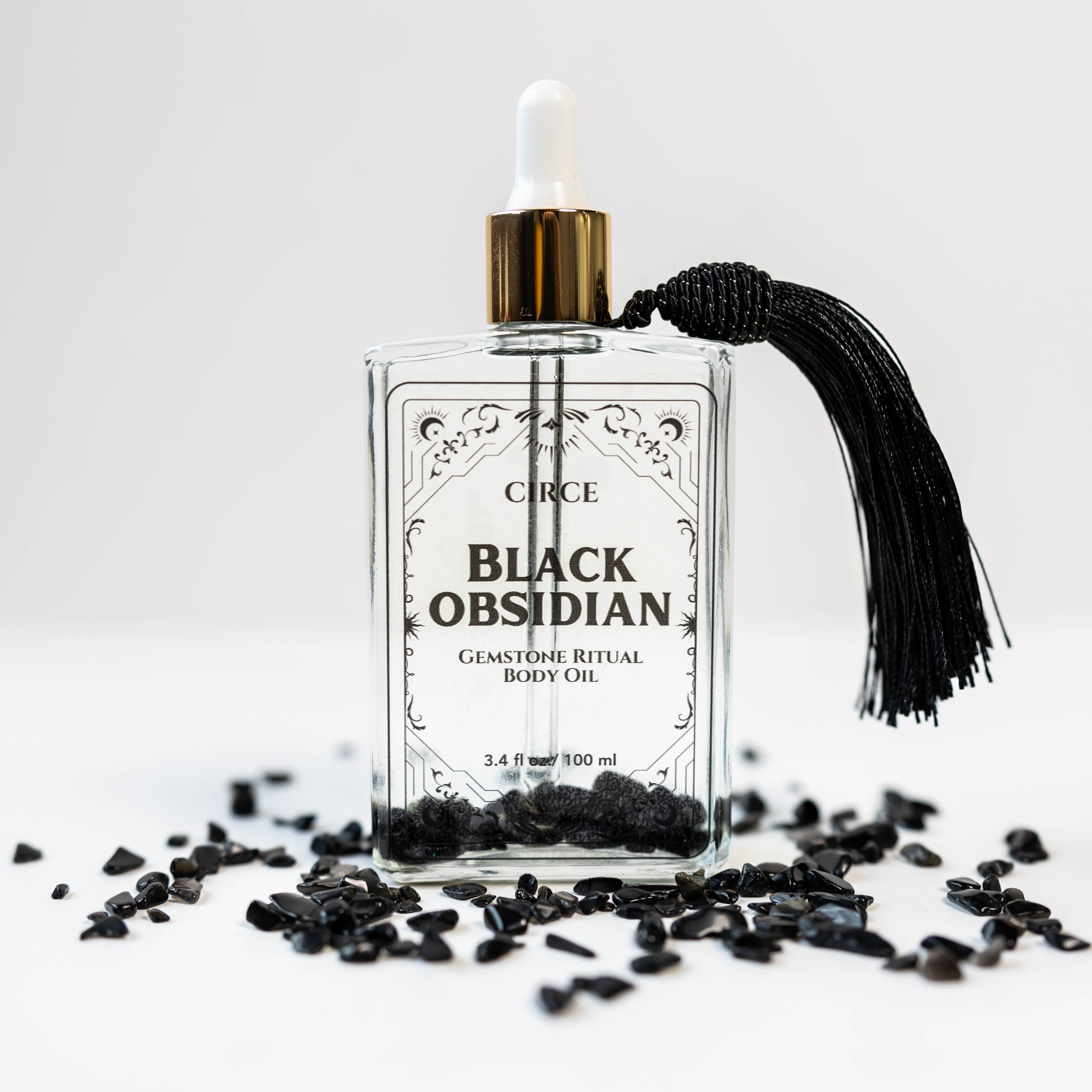 Black obsidian gemstone and ritual body oil from Circe Boutique, designed for protection and spiritual healing.