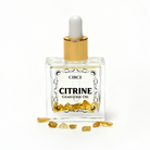 Citrine gemstone body oil from Circe Boutique Crystal Body Oil Trio with yellow-orange citrine stones and oil.