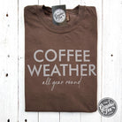 The Graphic Tee Coffee Weather All Year Round pigment-dyed SS graphic t-shirt with coffee-themed design on front.