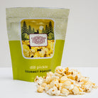 Dill pickle flavored popcorn from Colorado Popcorn Company in a 2 oz bag, showing green popcorn with pickle seasoning.