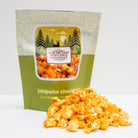 Jalapeño cheddar popcorn in a 2 oz bag from Colorado Popcorn Company, with vibrant green jalapeños and cheesy popcorn visible.