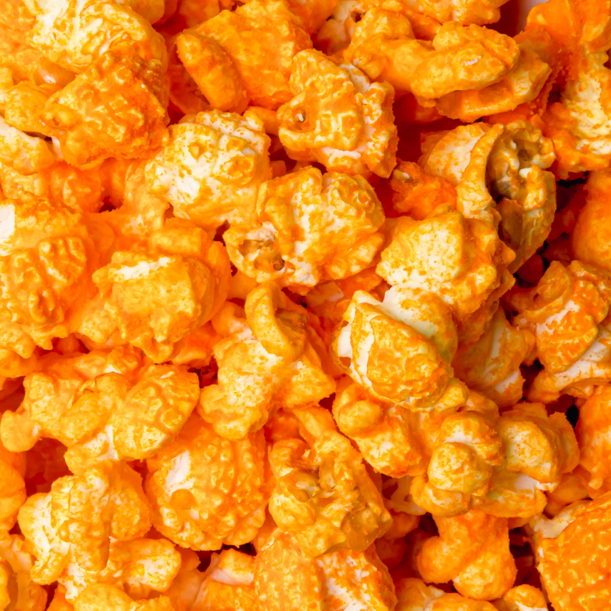 Yellow Cheddar Popcorn by Colorado Popcorn Company, 2 oz bag featuring vibrant yellow cheddar-coated popcorn kernels.