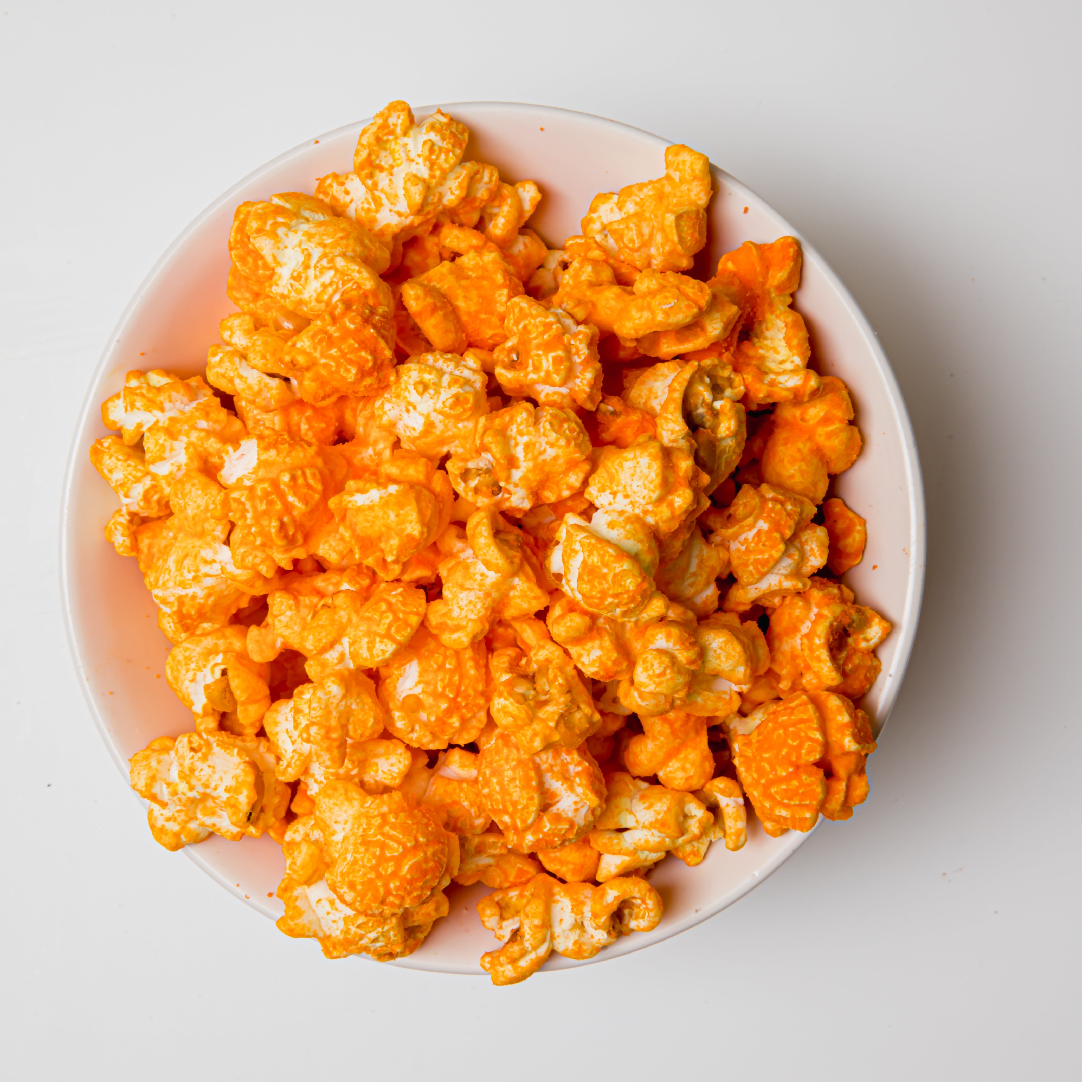 Yellow Cheddar Popcorn by Colorado Popcorn Company in a 2 oz bag, showing vibrant yellow cheddar-coated popcorn kernels.