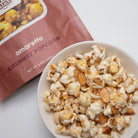 Amaretto flavored popcorn in a 5 oz bag from Colorado Popcorn Company, showcasing golden, coated popcorn pieces.
