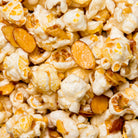 Amaretto flavored popcorn from Colorado Popcorn Company in a 5 oz bag, showing caramel-coated popcorn with a glossy finish.