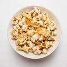 Amaretto flavored popcorn in a 5 oz bag from Colorado Popcorn Company, with caramel and almond glaze visible.
