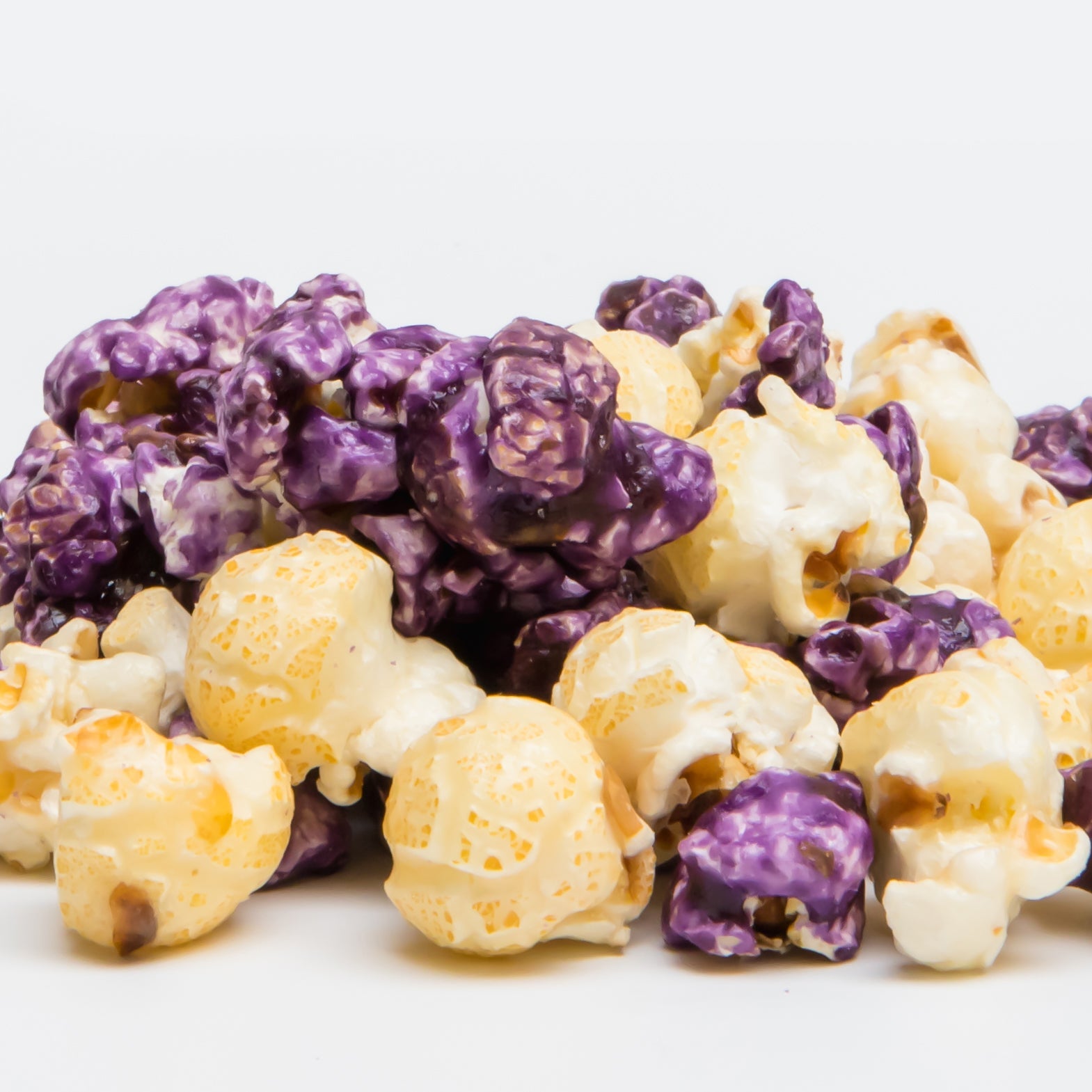 Blueberry cheesecake popcorn in a clear bag from Colorado Popcorn Company, showing blue and purple popcorn pieces with blueberries.