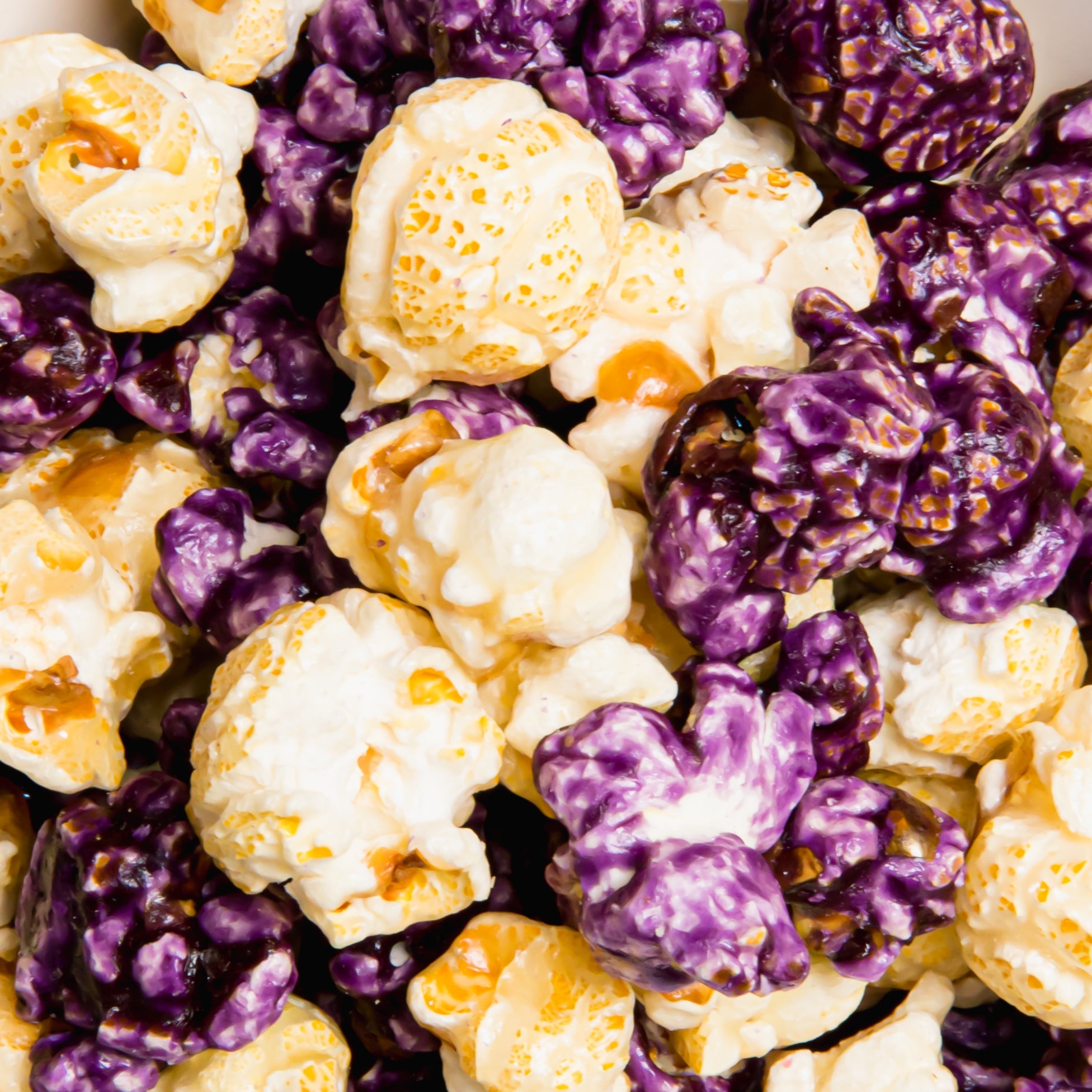 Blueberry cheesecake flavored popcorn from Colorado Popcorn Company in a 5 oz bag, showing popcorn pieces with blueberry and cheesecake swirls.